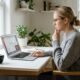 Person sitting at desk frustrated by laptop screen showing disabled Wi-Fi connection